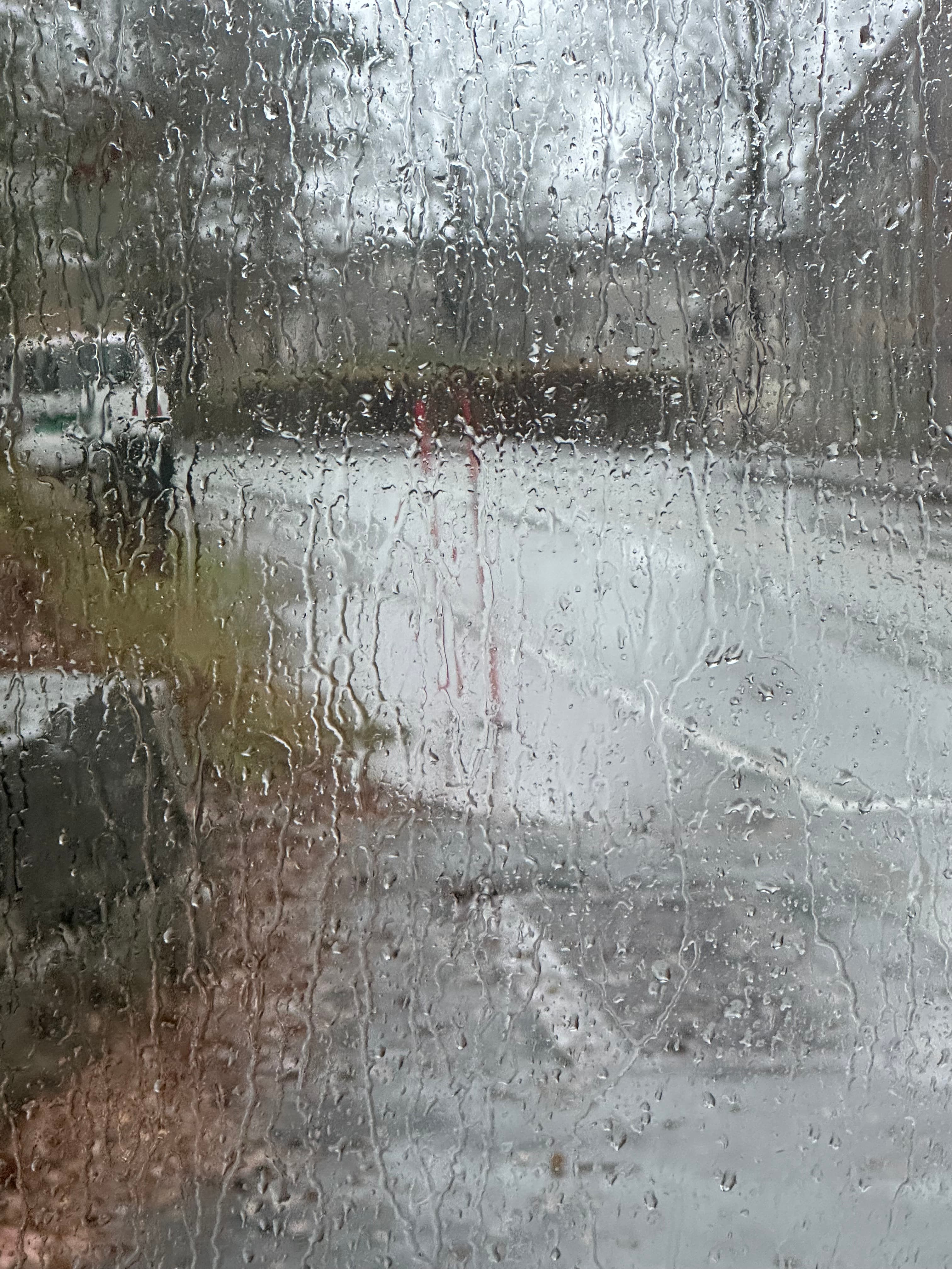 Abstract view through a window covered with running rain
