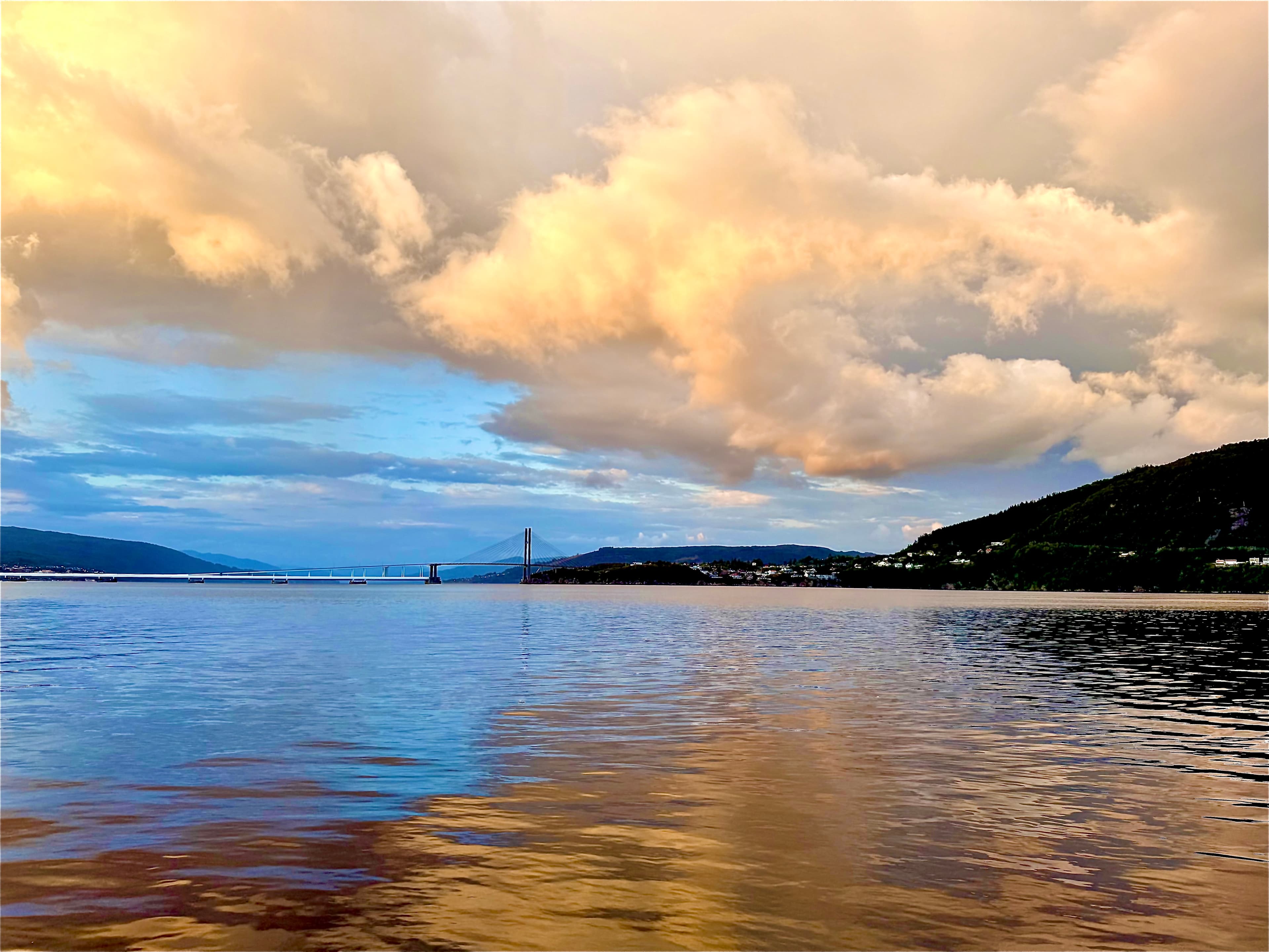 Golden clouds reflected in calm coastal water