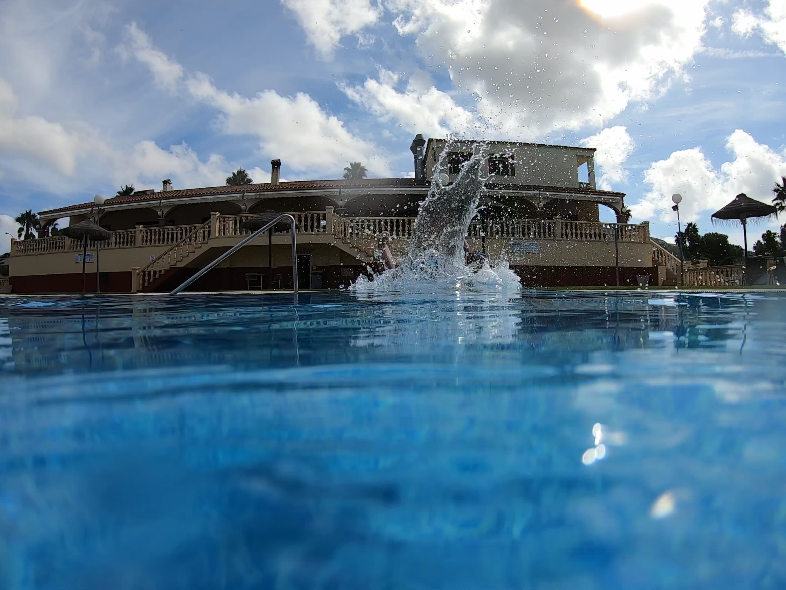 Water splashing above the blue surface of a swimming pool