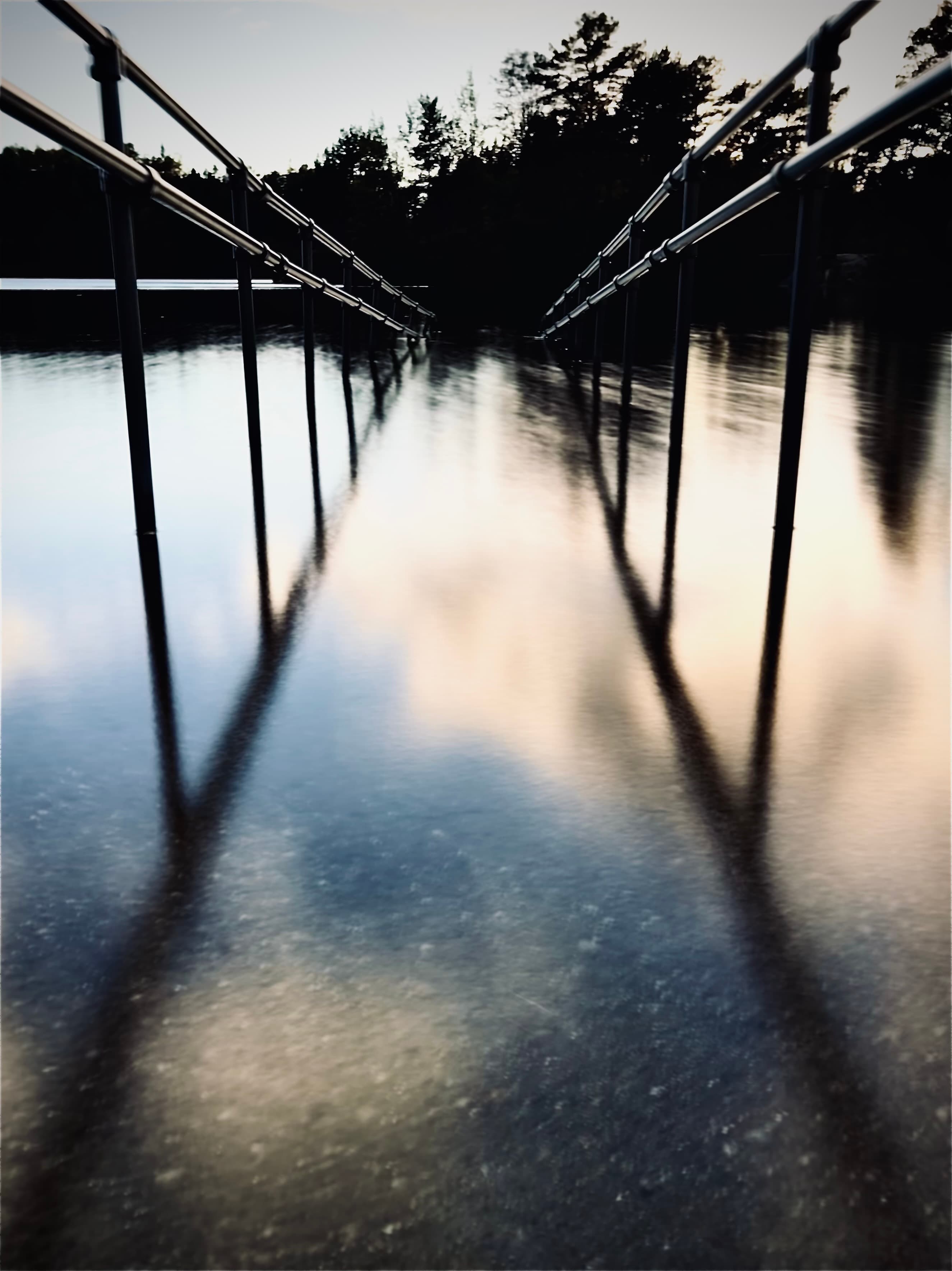 Soft reflections of posts stretching across still water